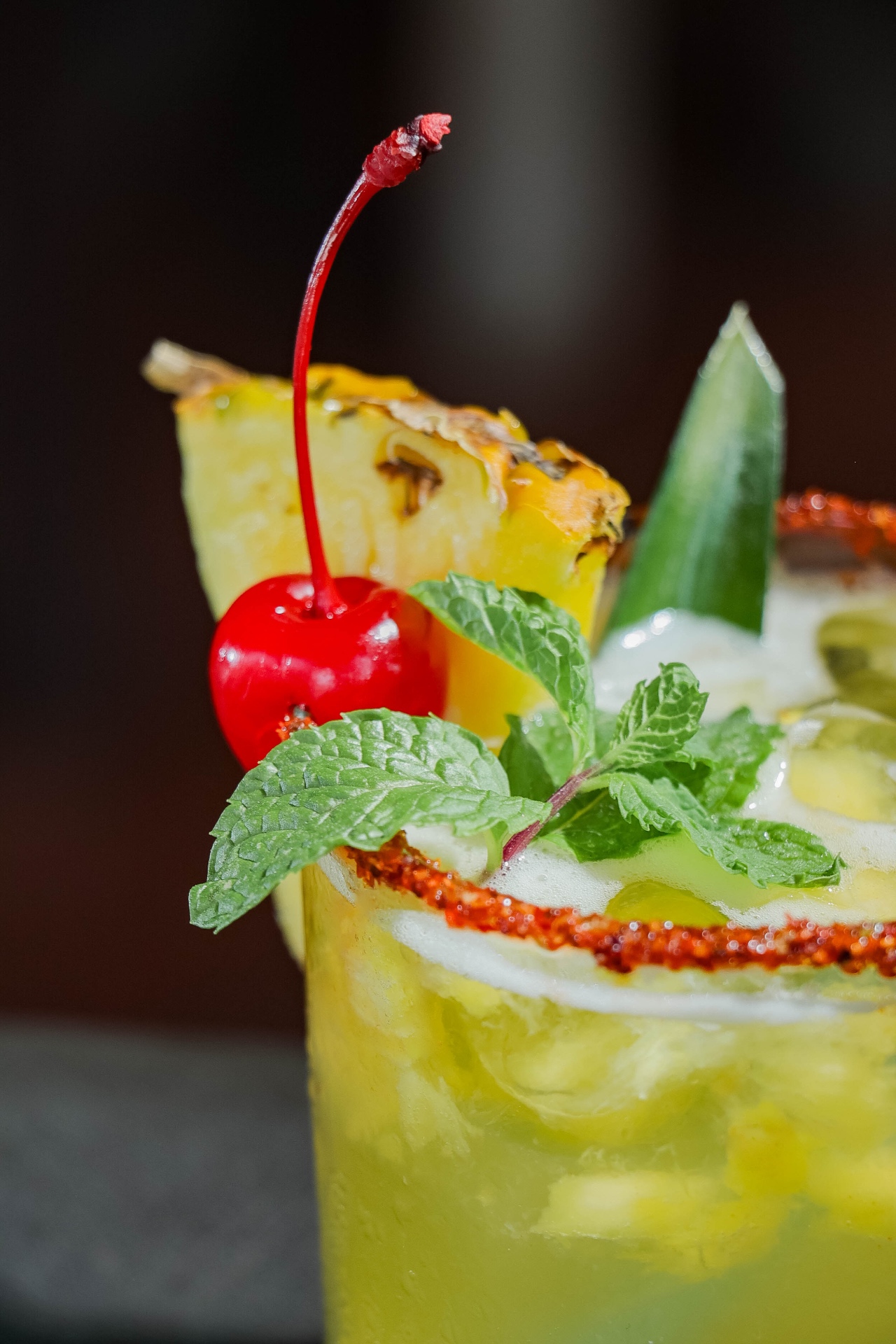 Crafted cocktail with pineapple, mint and chili rim